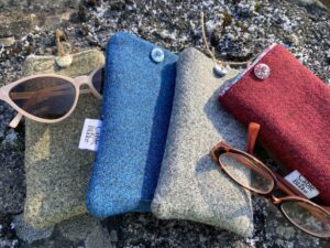 4 multicoloured glasses pouches with 2 pairs of glasses on concrete