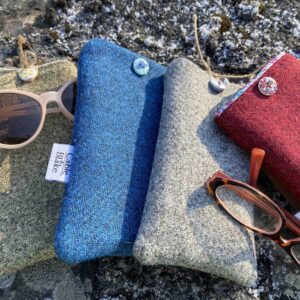 4 multicoloured glasses pouches with 2 pairs of glasses on concrete