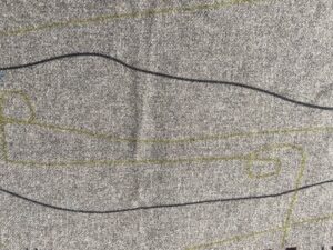 a close up of grey Cable & Blake fabric, with black and olive green lines meandering through it.