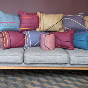 Many multicoloured scatter cushions placed on a grey sofa